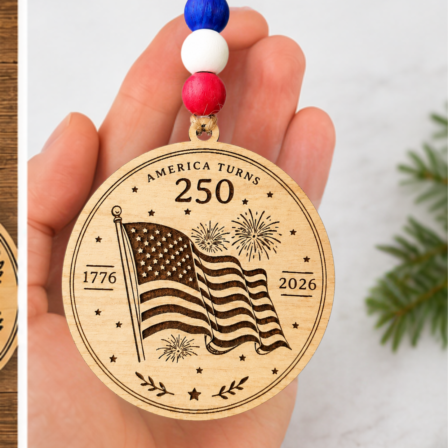 Handcrafted wooden America 250 ornament featuring Flag. Laser engraved patriotic keepsake with red, white, and blue bead accents celebrating America's 250th anniversary.
