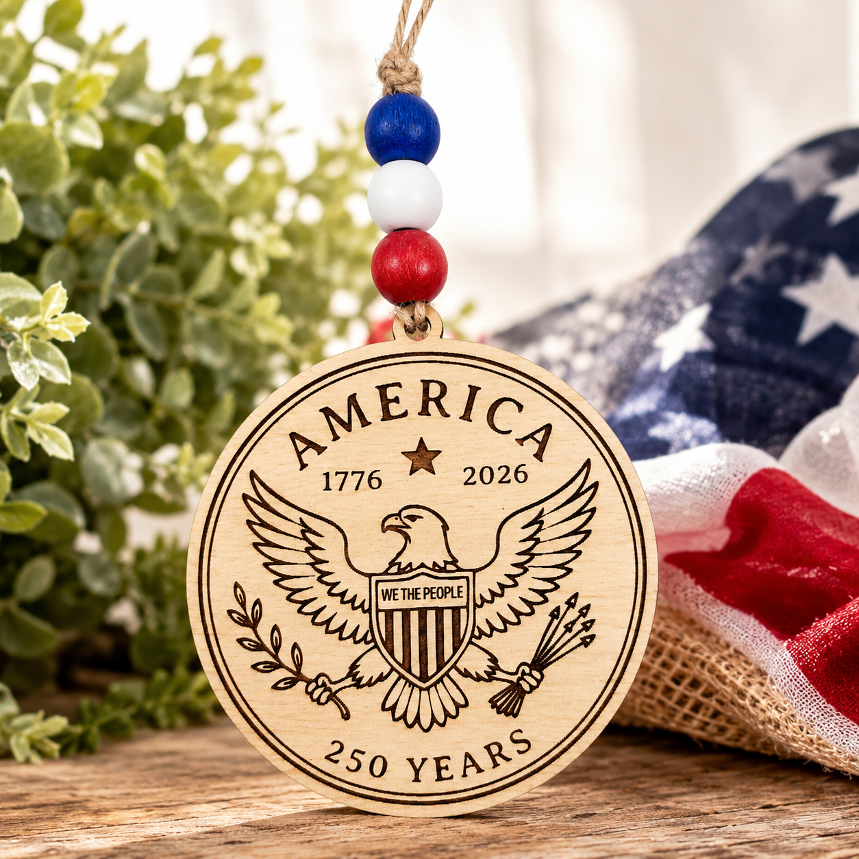 Handcrafted wooden America 250 ornament featuring Eagle. Laser engraved patriotic keepsake with red, white, and blue bead accents celebrating America's 250th anniversary.